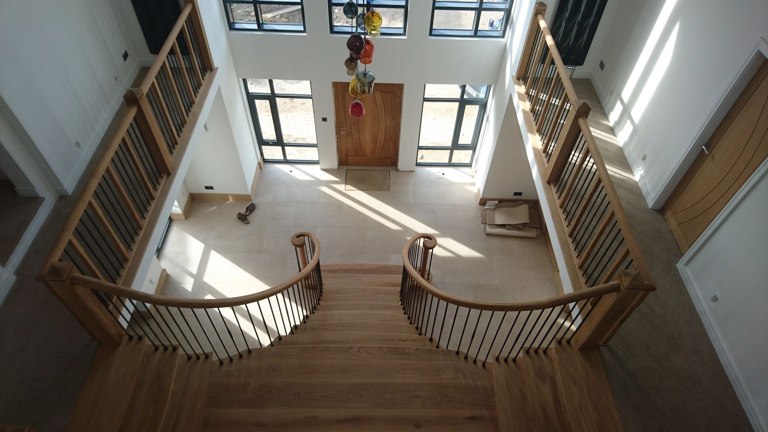 Hand-carved staircase starting step curtail and swept handrail detail in natural timber