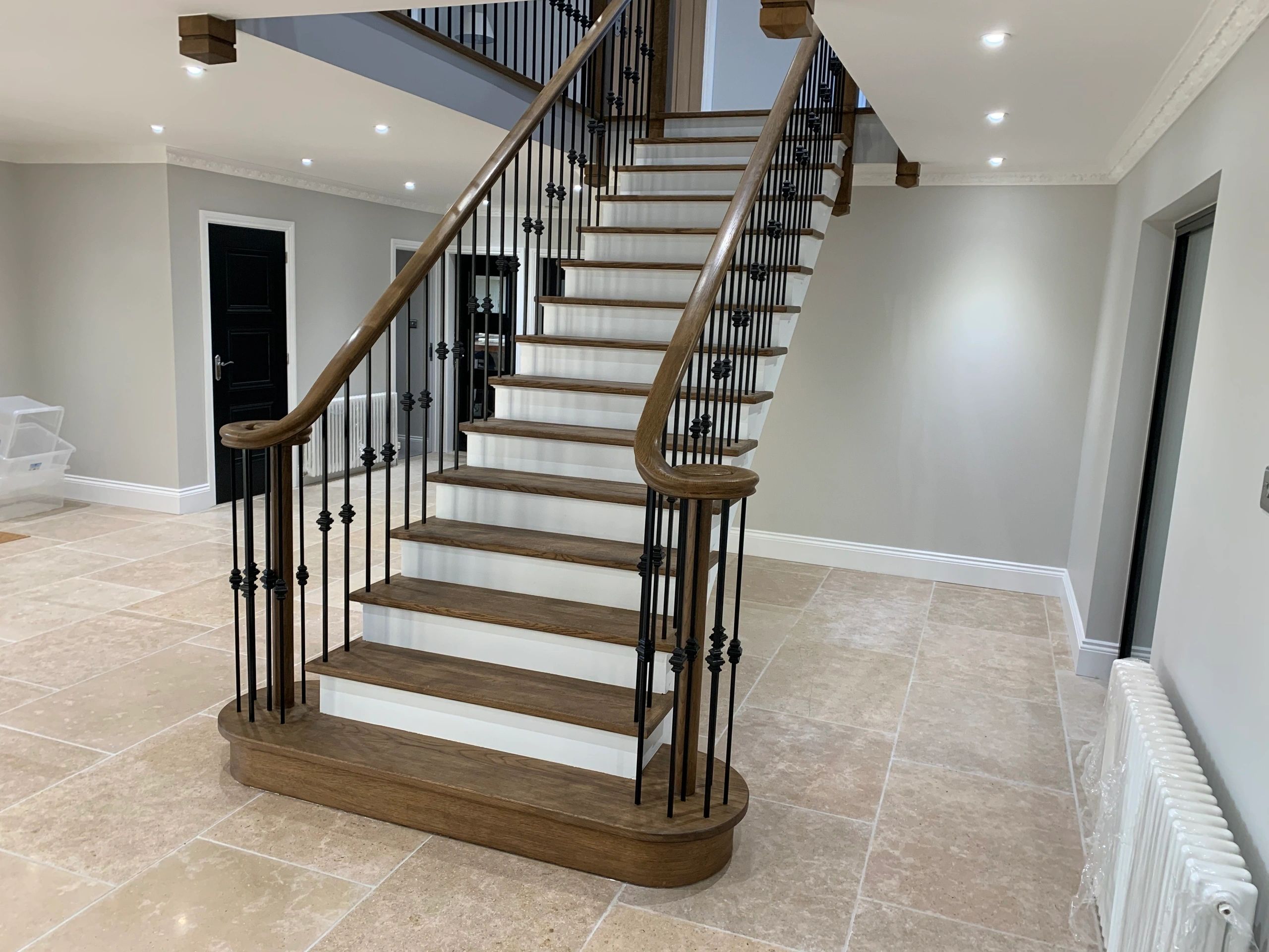Open rise staircase with glass riser panel and solid timber landing gallery balustrade